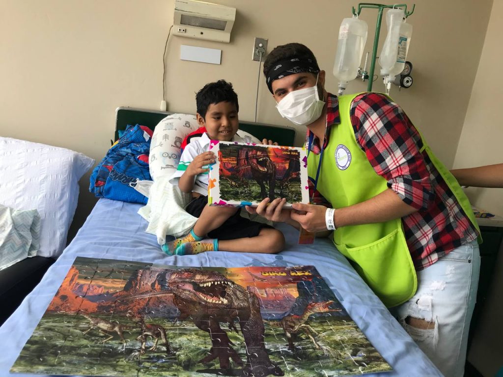 Léo ajudando uma criança no hospital - intercâmbio AIESEC